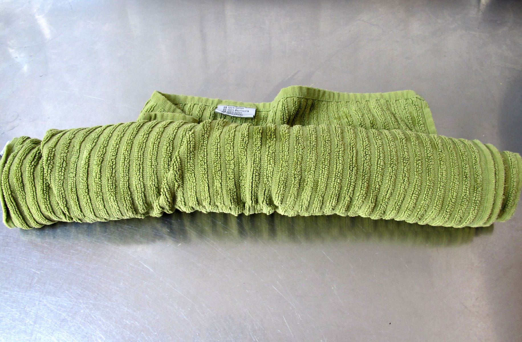 Image description: A rolled up light-green towel.
