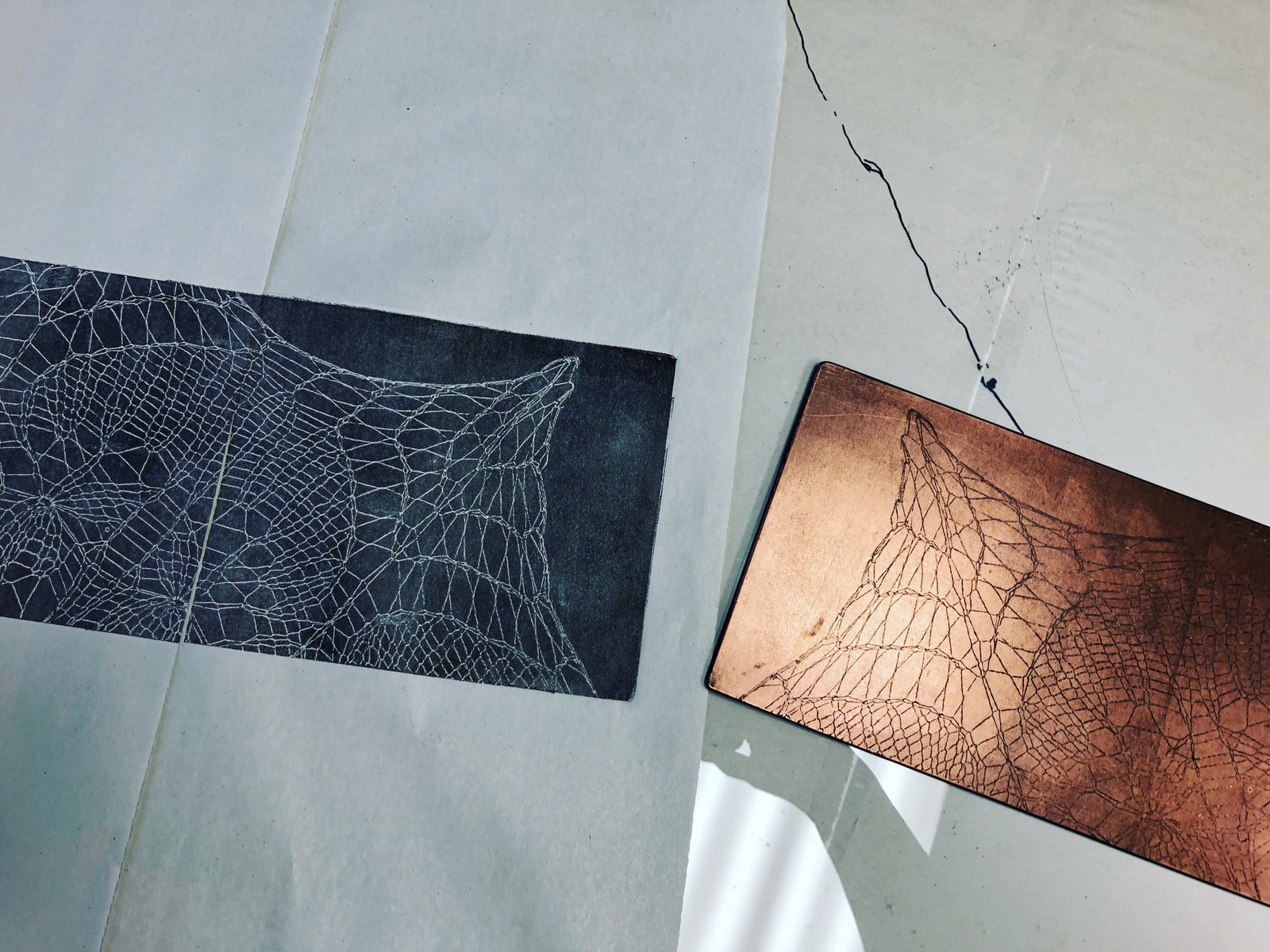 image: a copper etching of the shawl on the right, a test print on the left