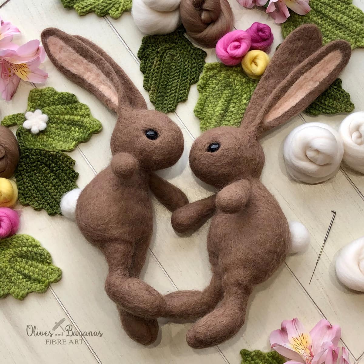 image description: two rabbit toys made from wool felt
