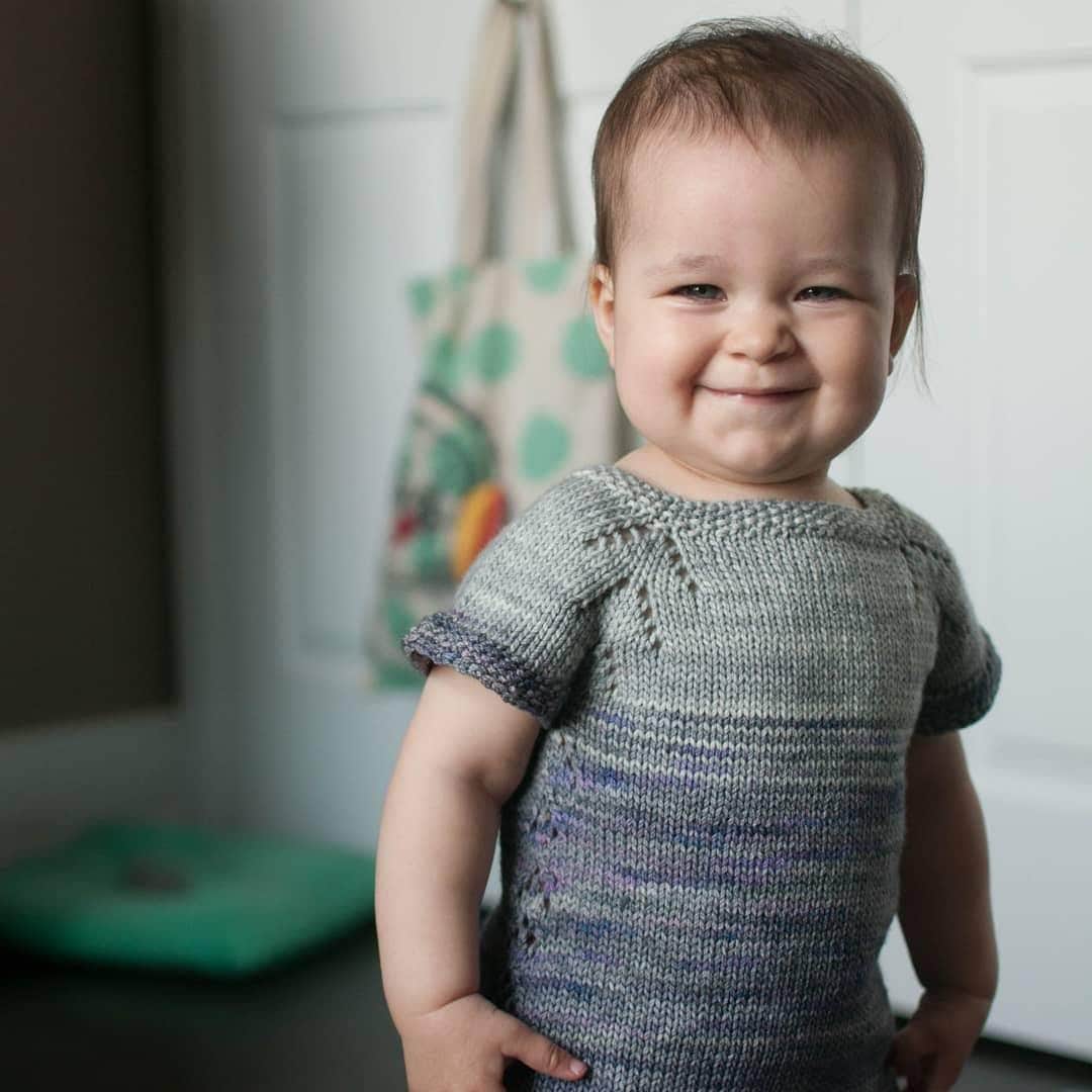 image description: a young child, wearing a handknit sweater, looking directly at the camera