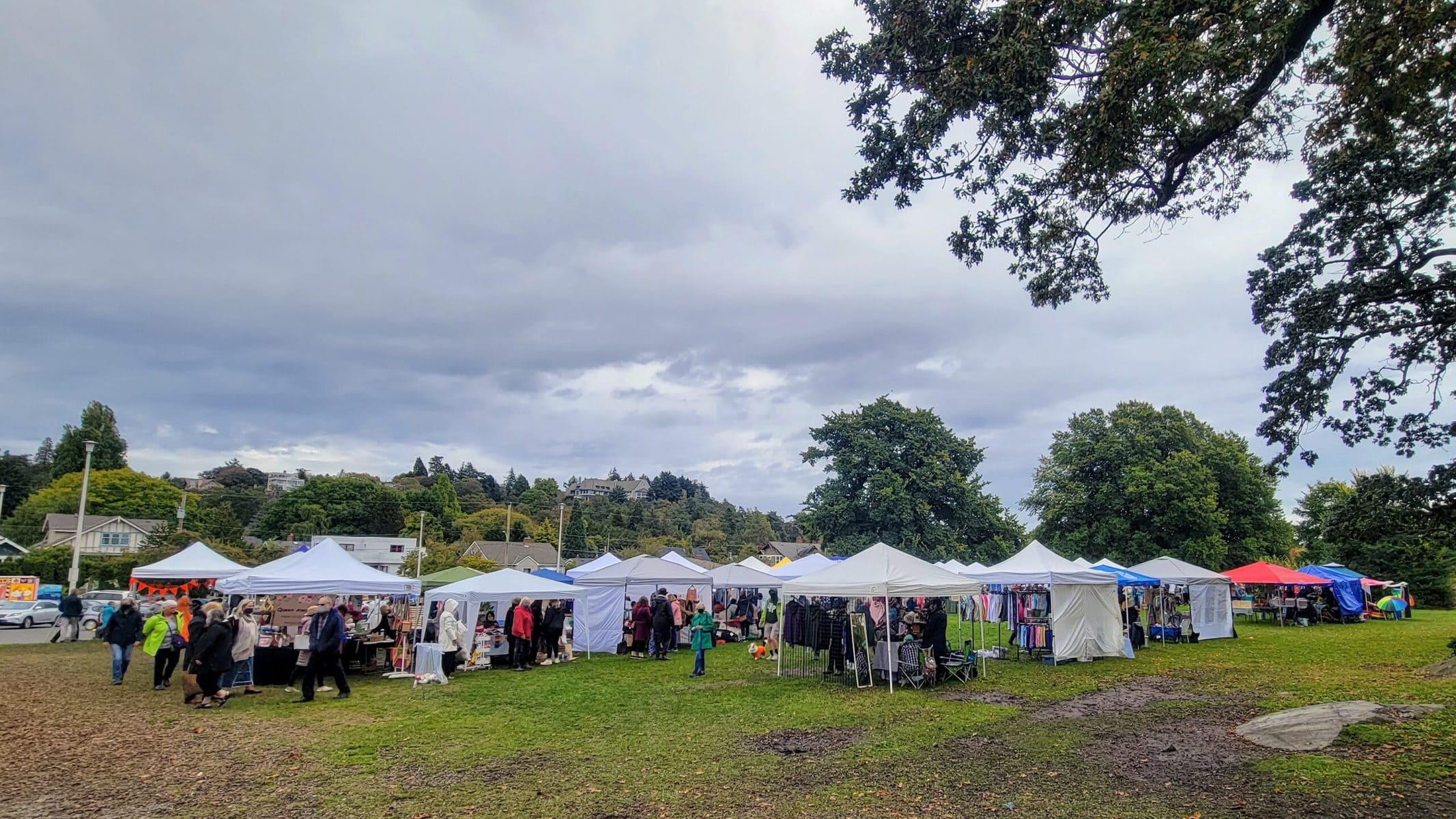 Image description: A view of outdoor tent booths at Fibrations Festival, under a cloudy sky.