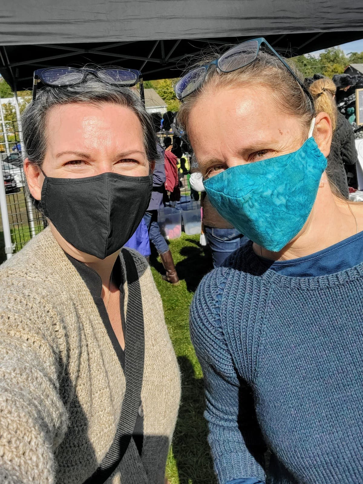 Image description: Two white women wearing face masks pose for a selfie.