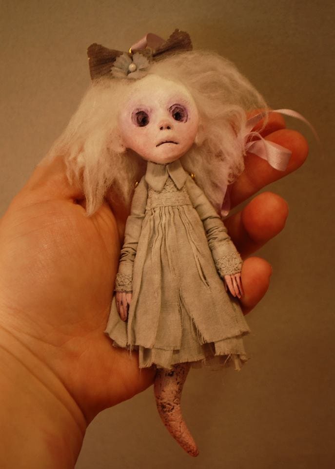 image description: a small handmade doll, held in the artist hand