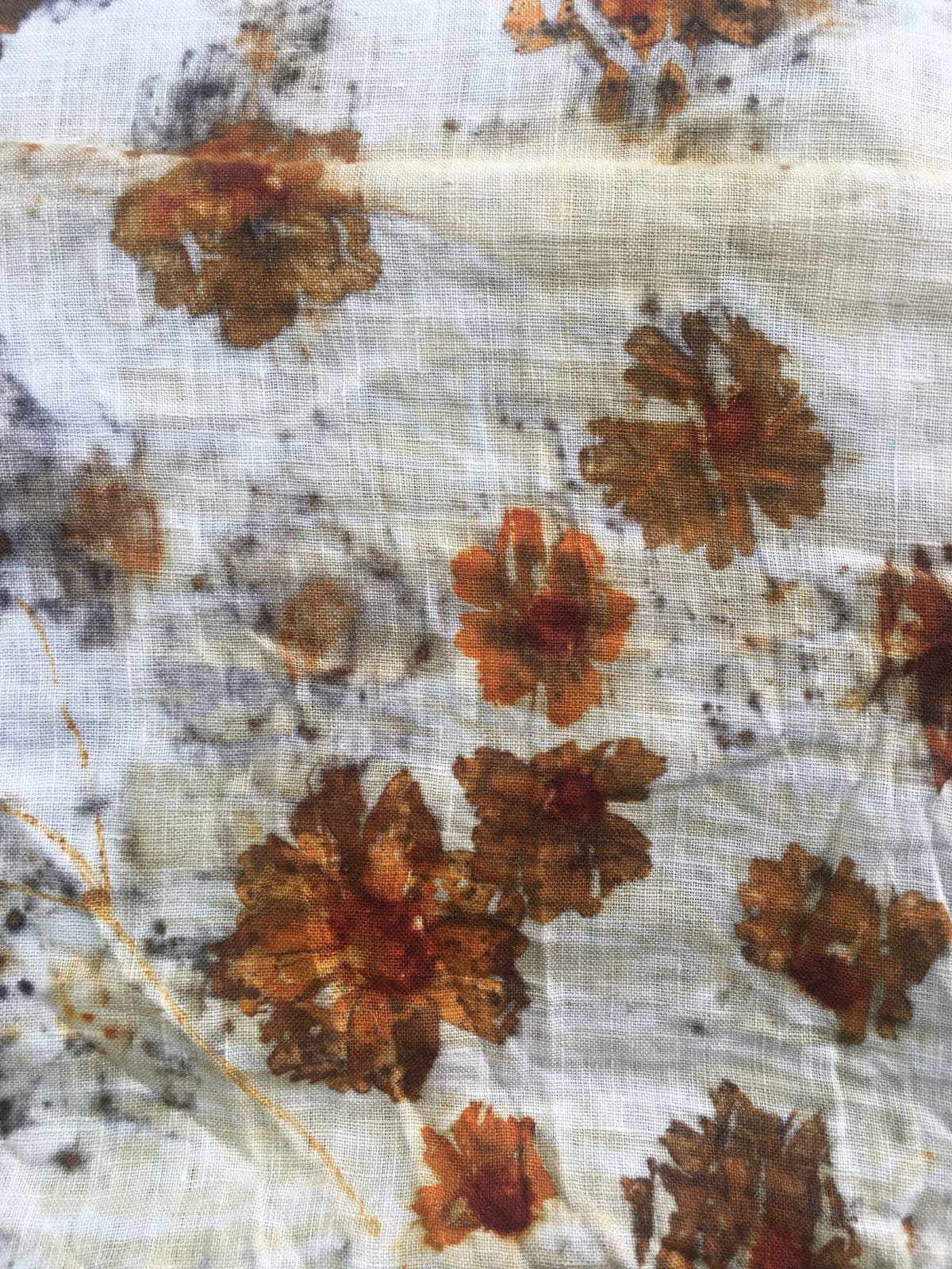 image description: ecoprinted fabric, orange and brown flowers on white fabric